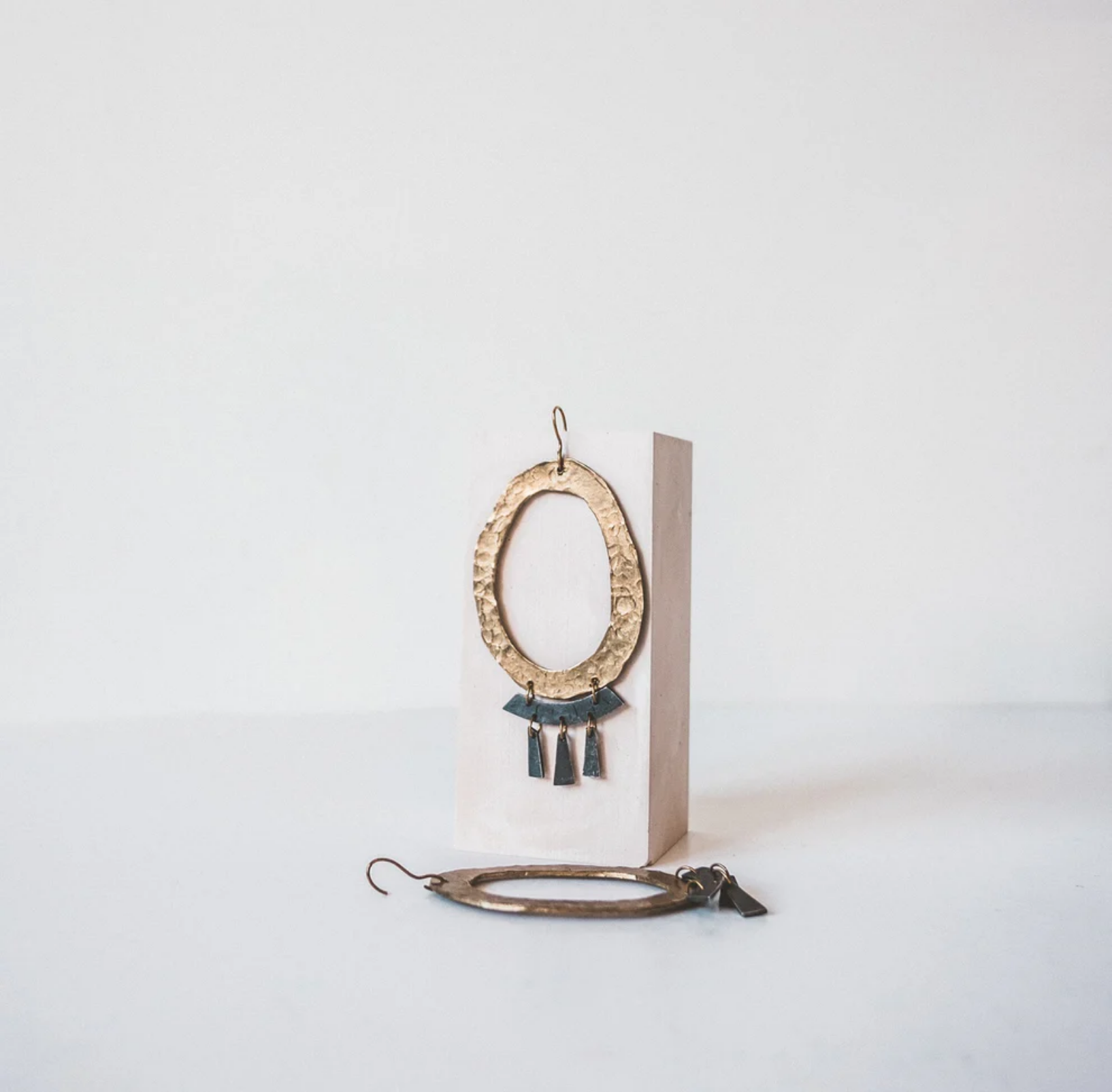 Gold earrings on display by Daria Fox