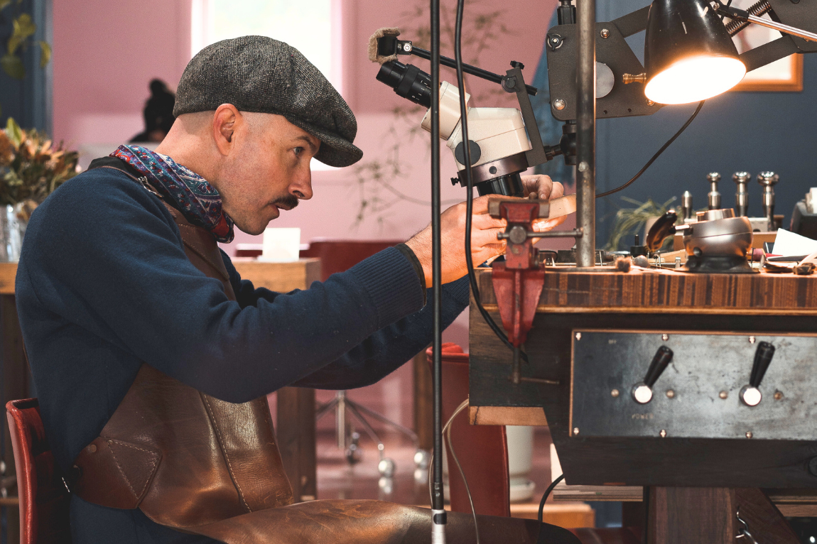 Male jeweller working on a piece of jewellery at his desk