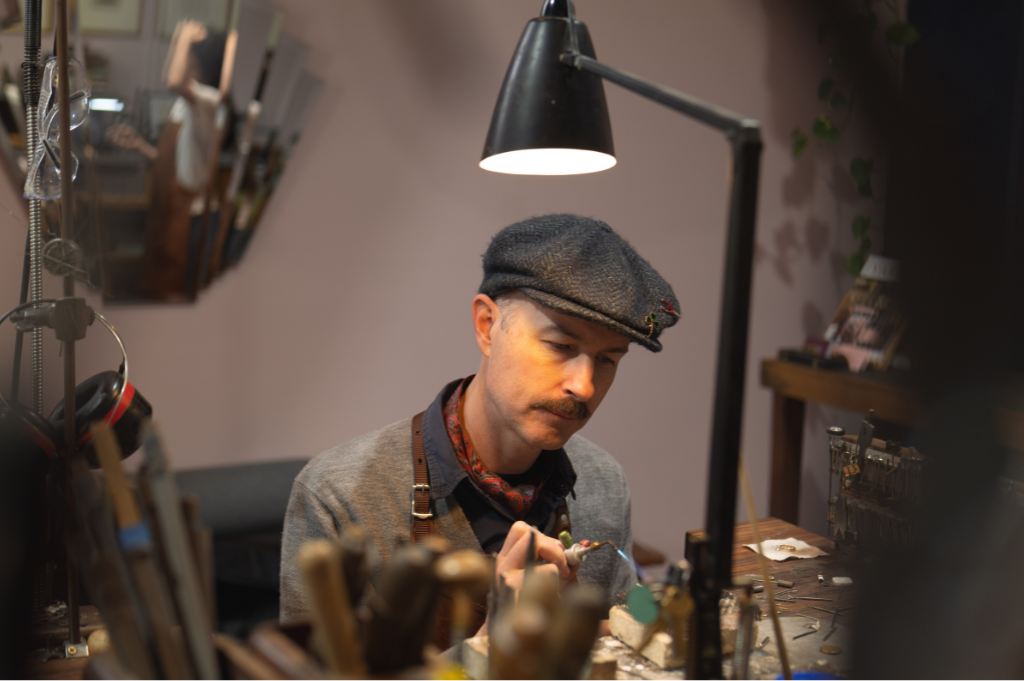 Jeweller crafting a custom ring with precision blowtorch work.