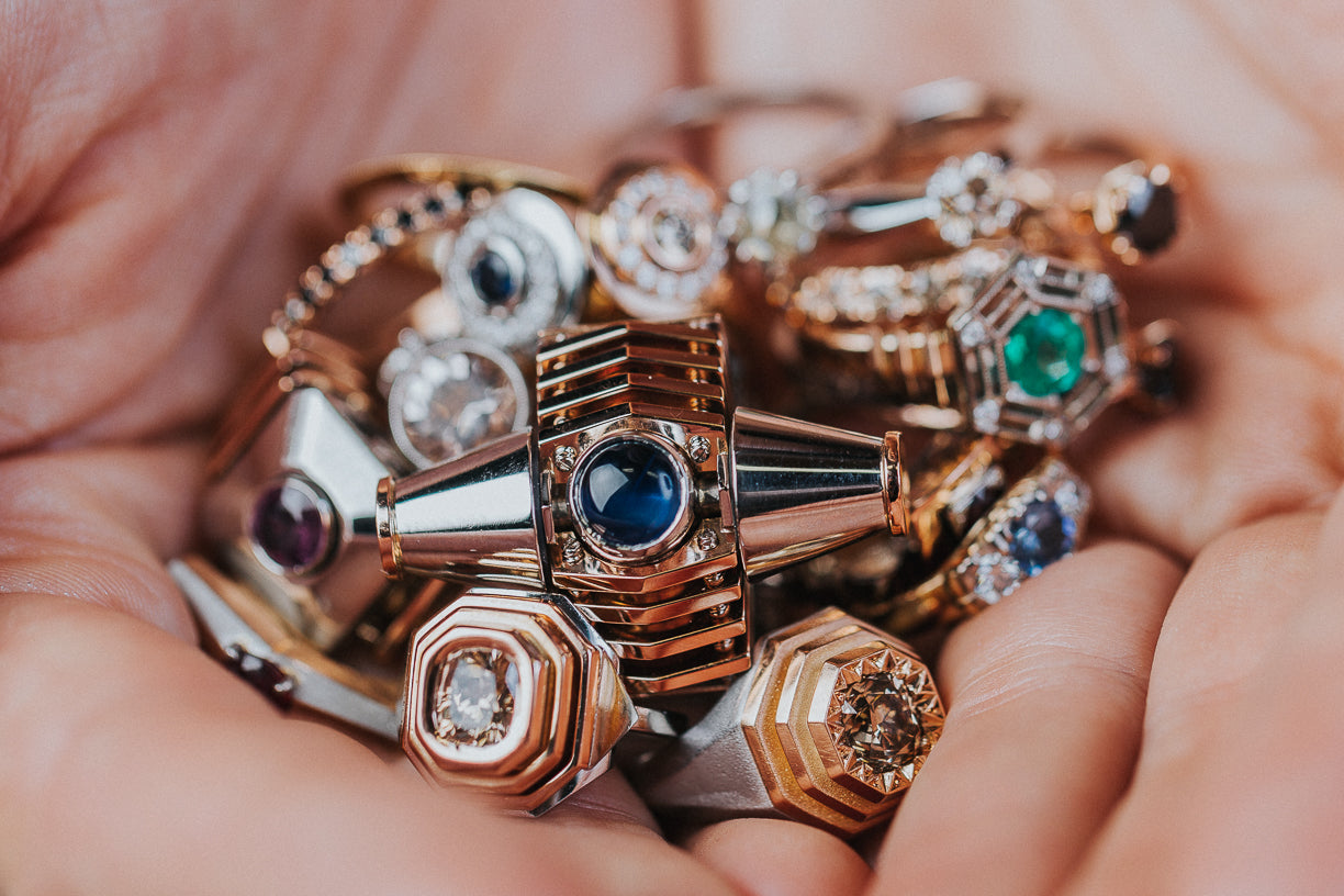 Hand holding a number of different custom made engagement rings