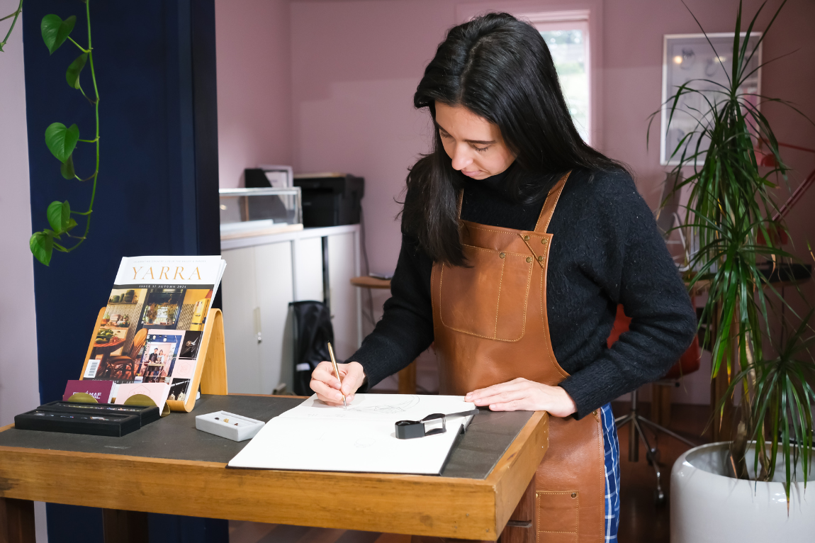 female jeweller drawing a ring design for a customer