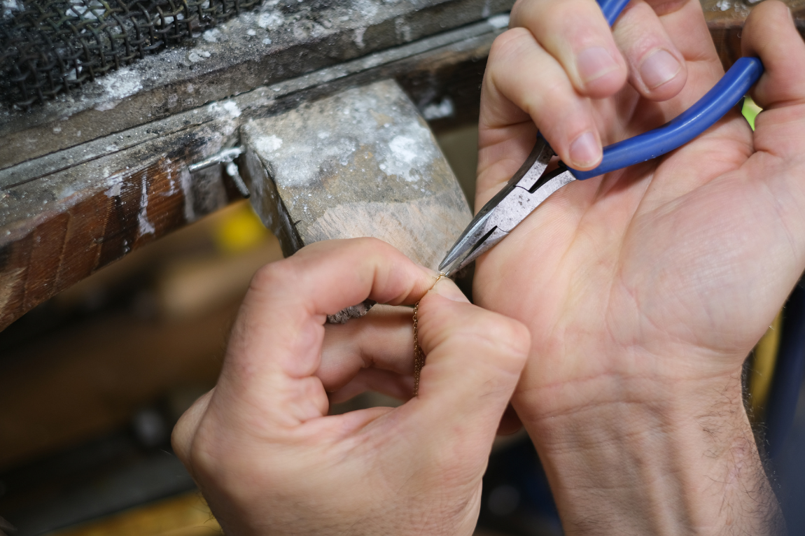 Close up of jewellers using a pair or pliers to repair a piece of jewellery