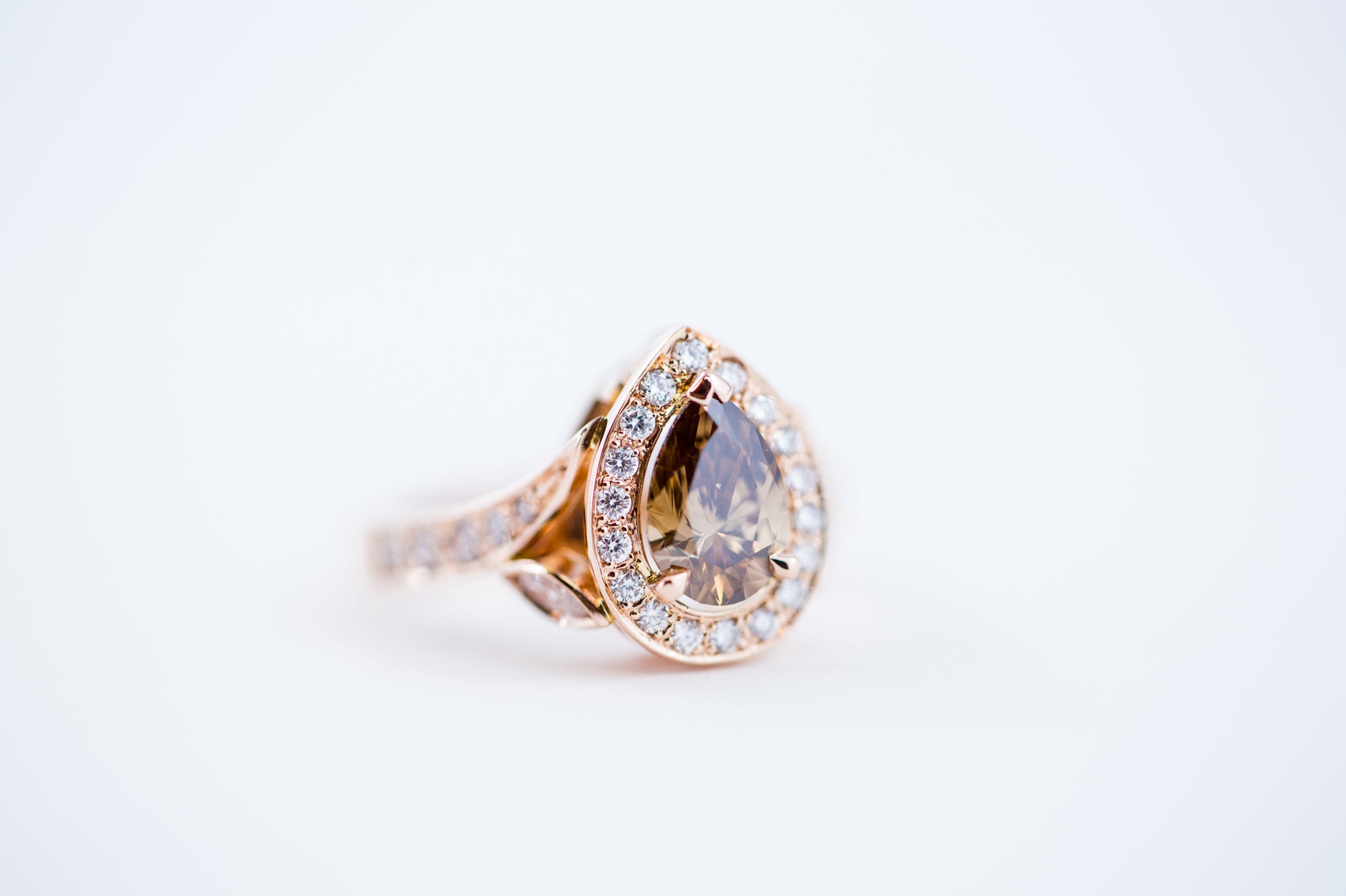 custom gold ring with diamonds and a centre sapphire stone