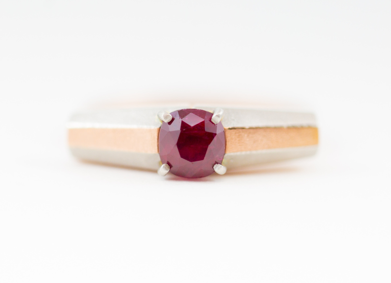 Close up of a  custom made gold ring with a red sapphire stone by Terry Cockrem